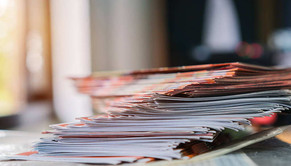 A stack of magazines with a blurry background.