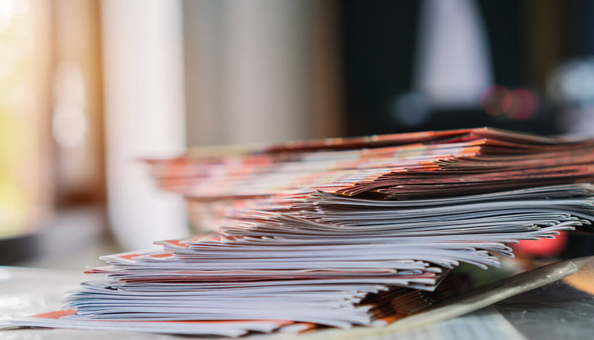 A stack of magazines with a blurry background.