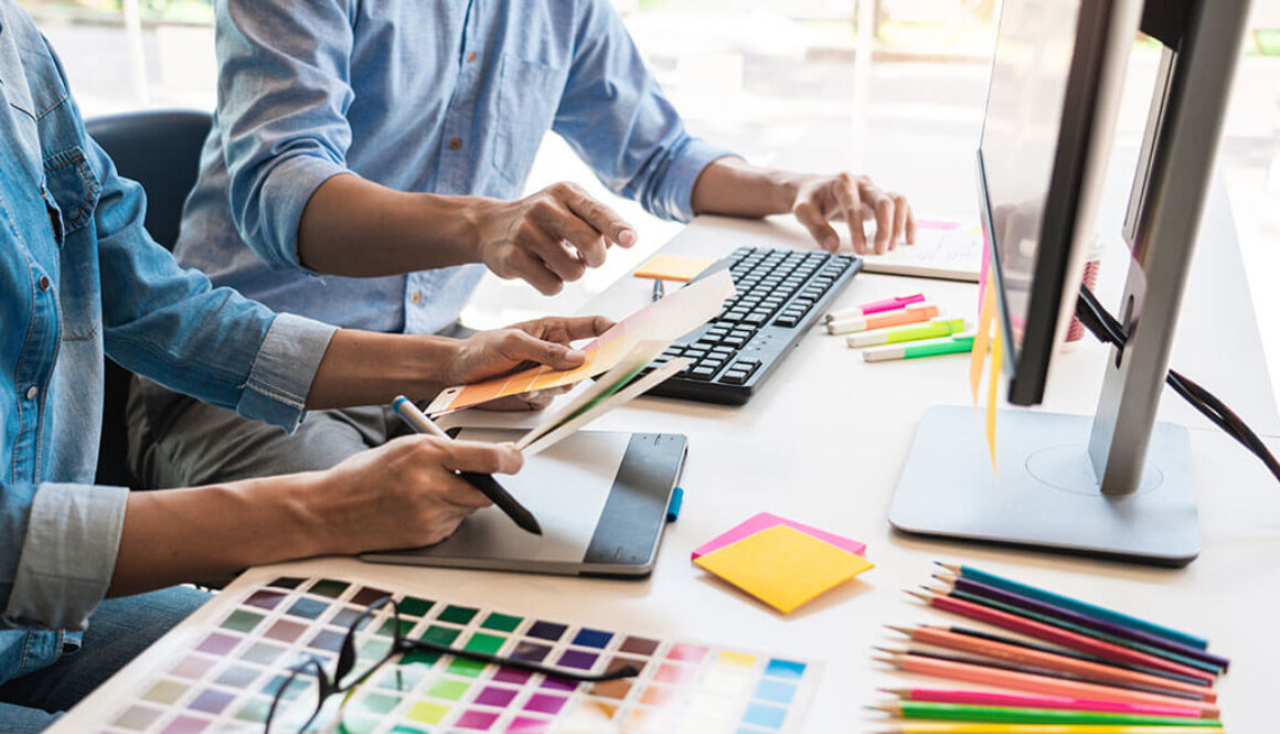 Creative desk with people looking at colour swatches.