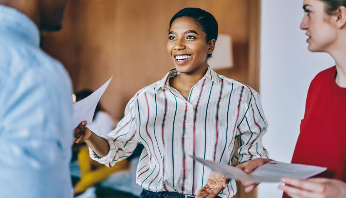 Young woman smiling at man while holding a piece of paper