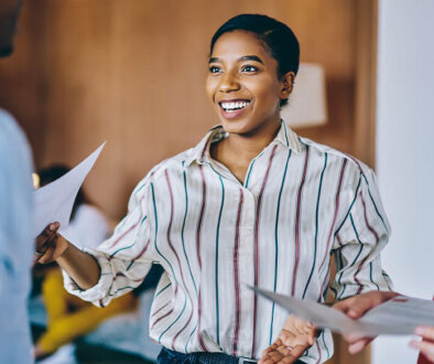 Young woman smiling at man while holding a piece of paper